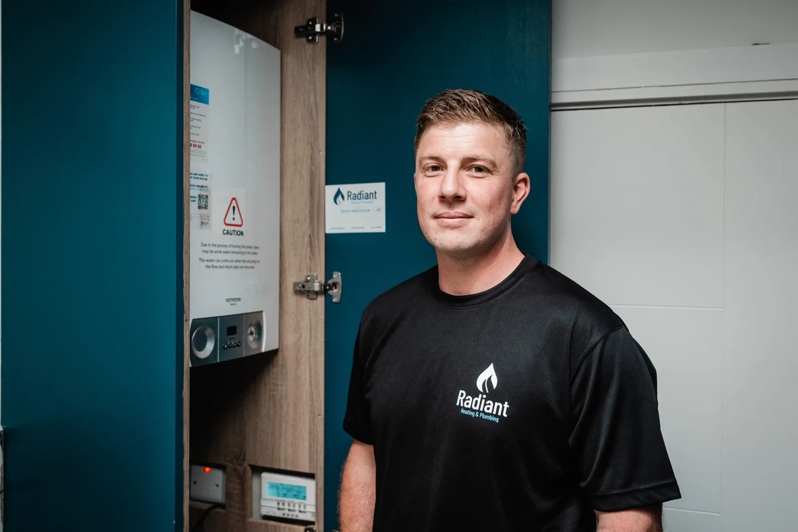 Gerard beside a serviced gas boiler with the Radiant service label fitted